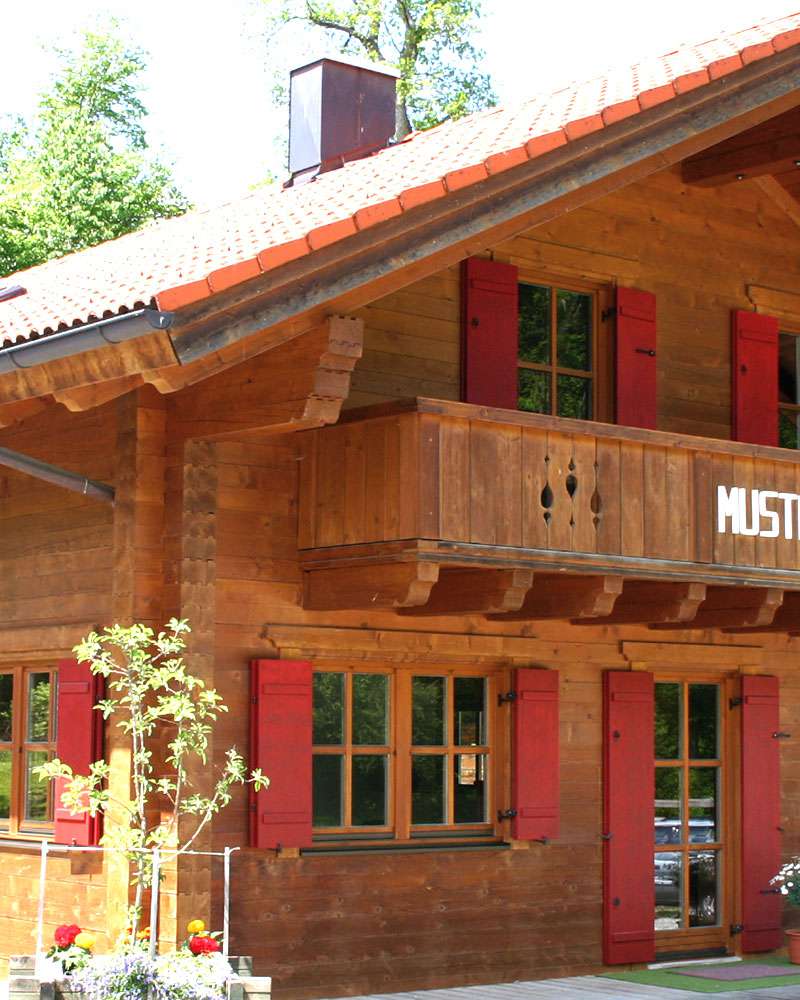 Musterholzhaus mit Balkon und roten Fensterläden 